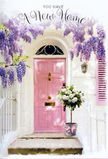 The scene shows a front entrance that feels deeply welcoming, the sort of doorway you might come across while wandering through residential lanes in Hook, where soft colours and flowers set the tone. At its centre is a blush-pink door, painted in a tender, chalky hue that looks both modern and nostalgic at once. The door's simple design allows its colour and the light glancing off its surface to take focus, giving it a warm, inviting presence. The wall surrounding it has been whitewashed, the subtle texture catching patches of light and shadow, while a nearby shutter - brushed in a slightly paler pink - echoes and gently softens the overall palette. Overhanging the doorway, wisteria branches spill downward, their lavender flower clusters hanging like delicate garlands. Each trail of blossoms seems to move softly, as though a light country breeze has just passed, and you can almost picture the sweet, faintly earthy scent drifting into the air, reminiscent of walking near open gardens around Hook on a spring afternoon. On the step below, a small grey metal bucket sits proudly at the threshold, used as an informal yet stylish container. It overflows with creamy white roses, each flower lush and layered, whose velvety petals catch the light with a subtle, pearly sheen. Between them, gentle tones of green foliage weave through, bringing freshness and a hint of natural spontaneity, as if the bouquet were freshly arranged by a local florist that morning. A soft pink ribbon encircles the bucket, tied neatly into a satin bow that coordinates delicately with the door's colour. Light filters down through the wisteria, casting soft shadows that dance across stone and wood, enclosing the entrance in a cocoon of calm. The overall impression is one of gentle optimism and intimate celebration, perfect for marking a new home in Hook with beauty, warmth, and a heartfelt sense of welcome.